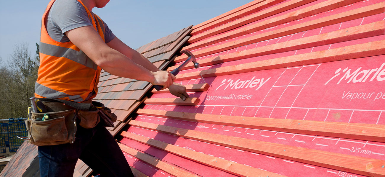 Work in progress on a roof with clay tiles